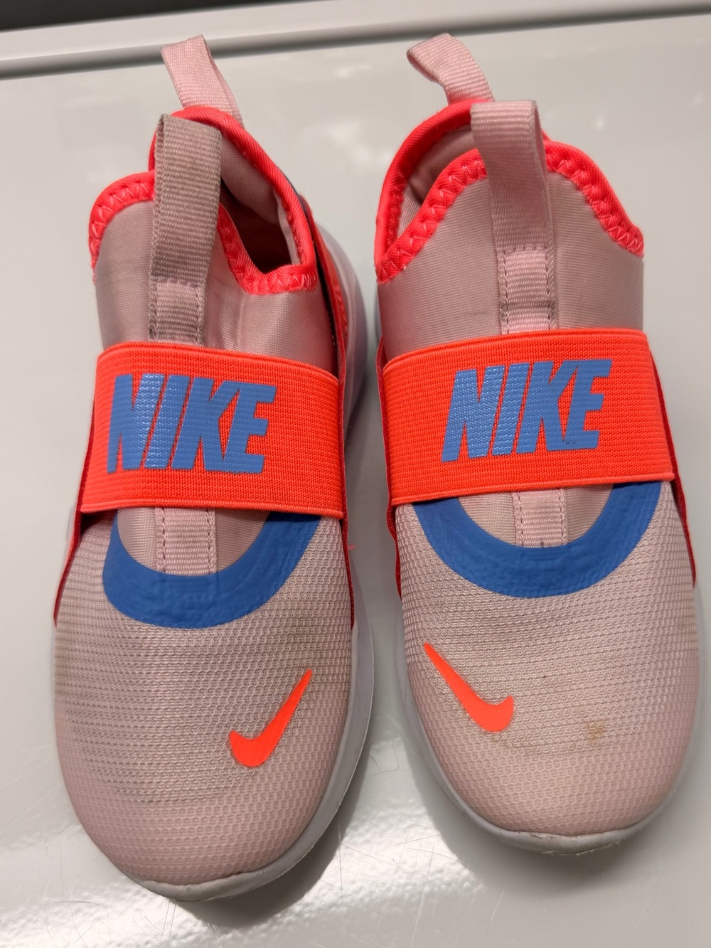 Nike Kids Slip-On Sneakers in Light Pink with Bright Orange and Blue Accents